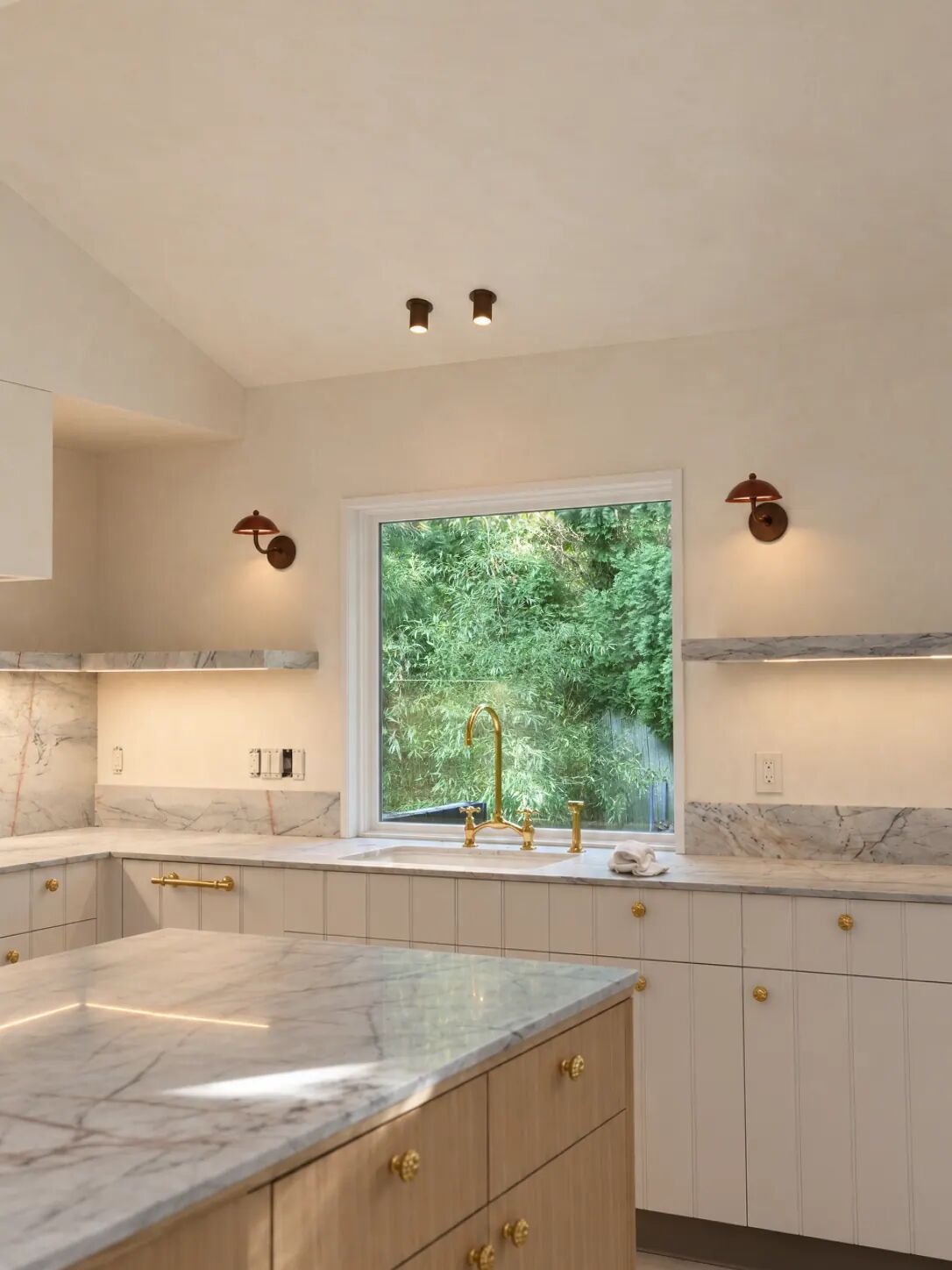 Kitchen with limewash walls and brass sconces, Hamptons residence